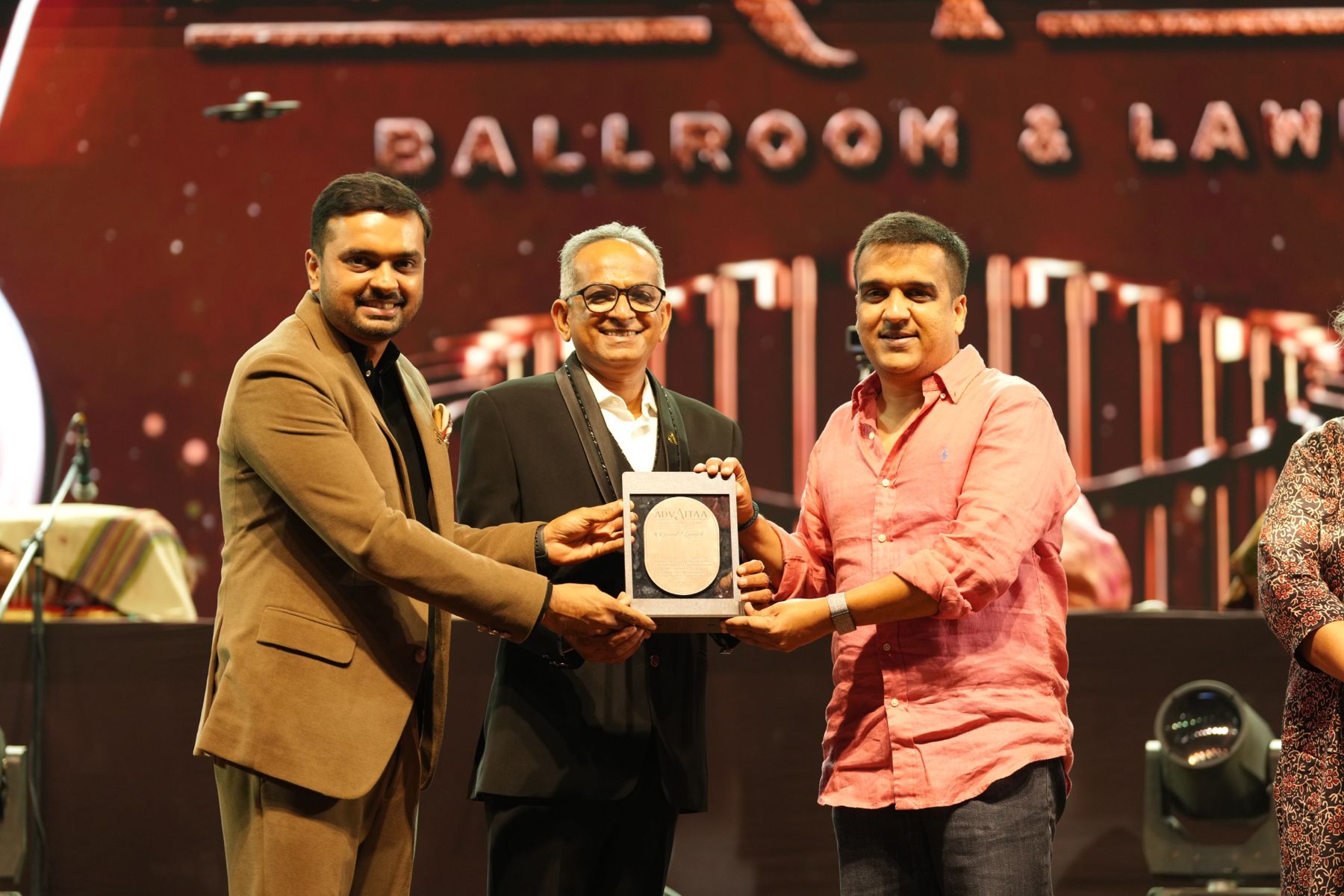 Parv Parmar presenting the ADVAITAA grand launch plaque on stage