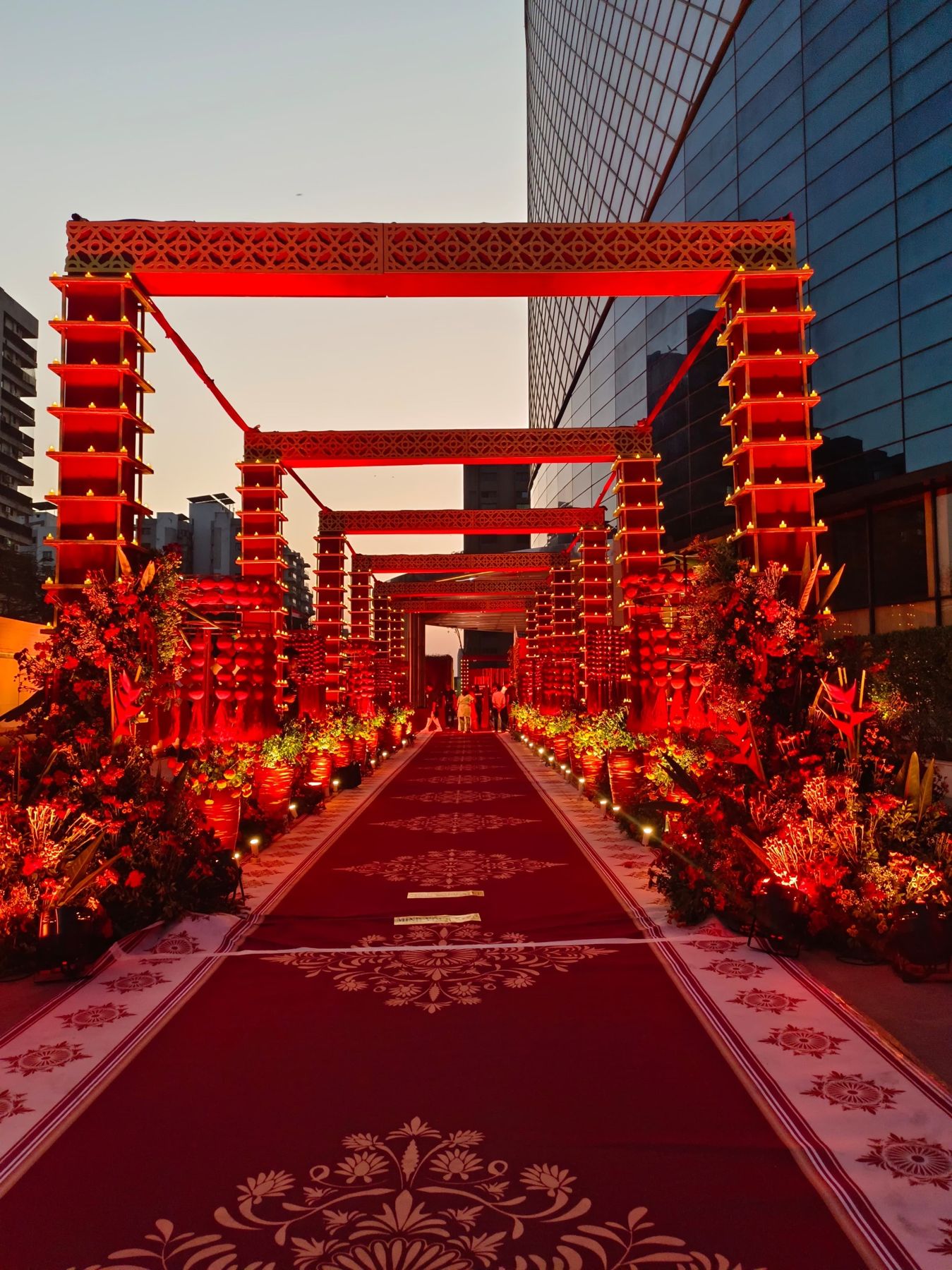 Red lit corridor of jaali arches lined with diyas and florals